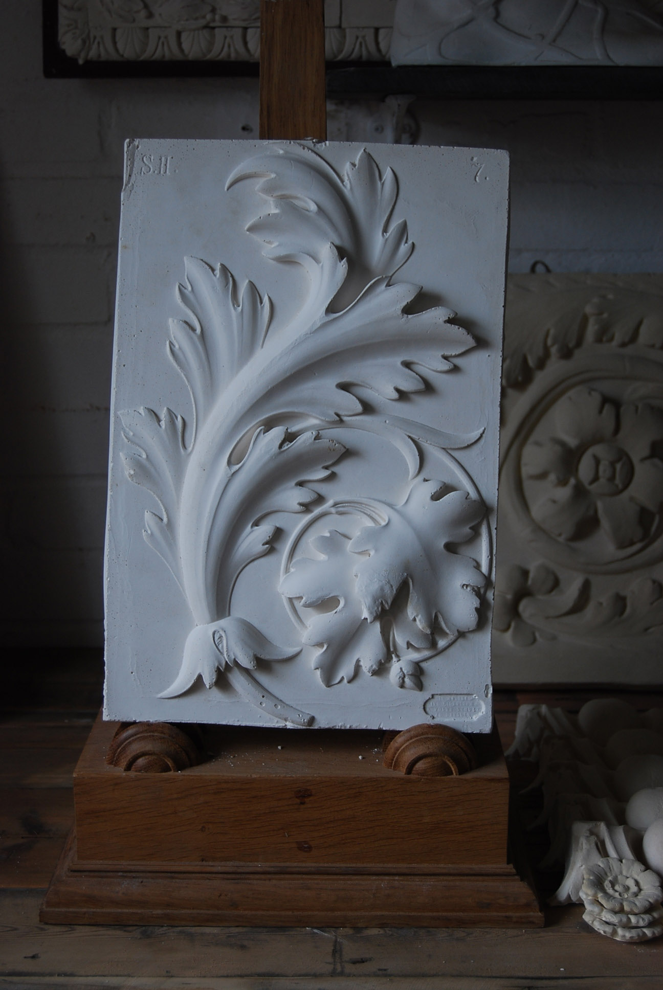A cast plaster relief depicting a spray of acanthus leaves-0