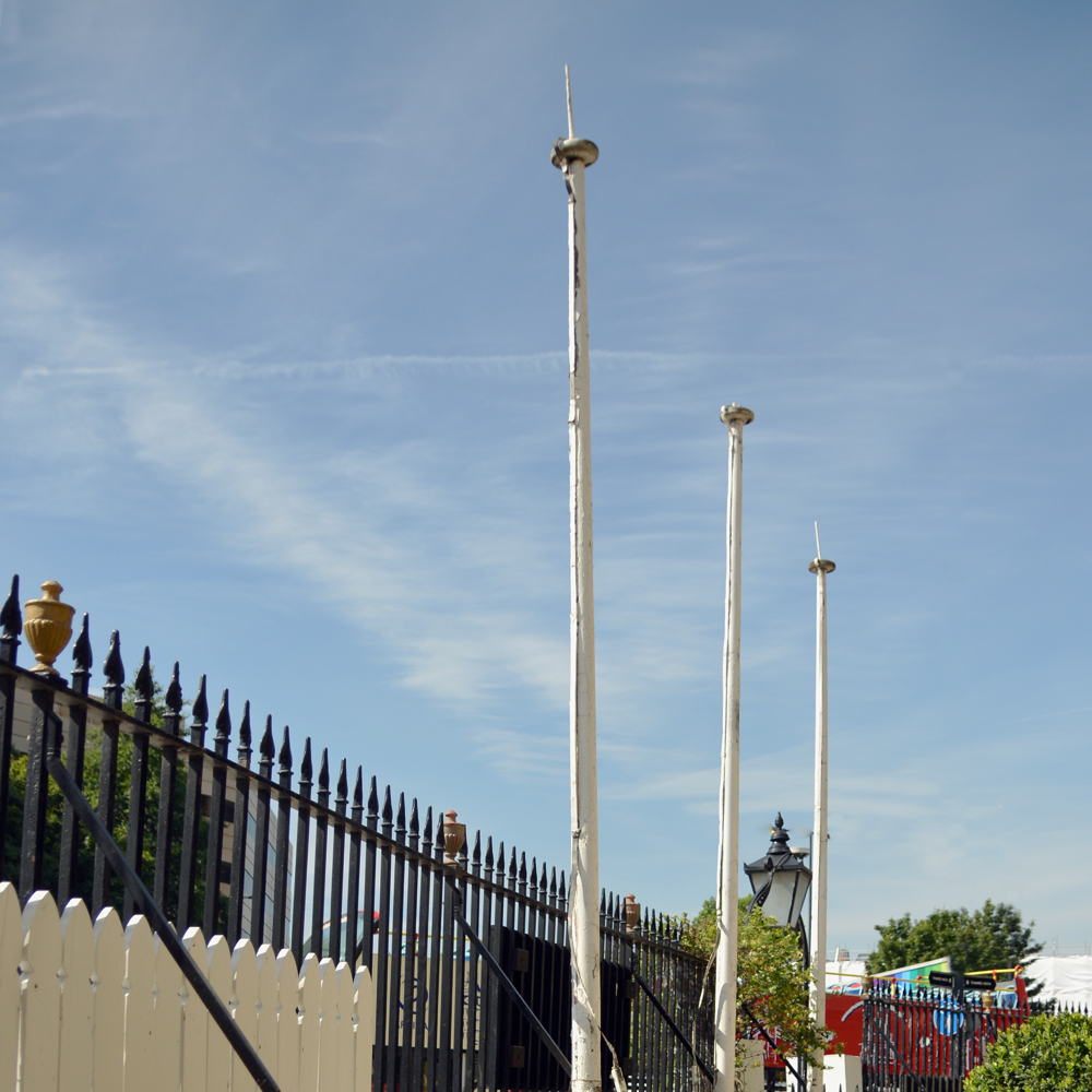 A set of three wooden flagpoles,-0