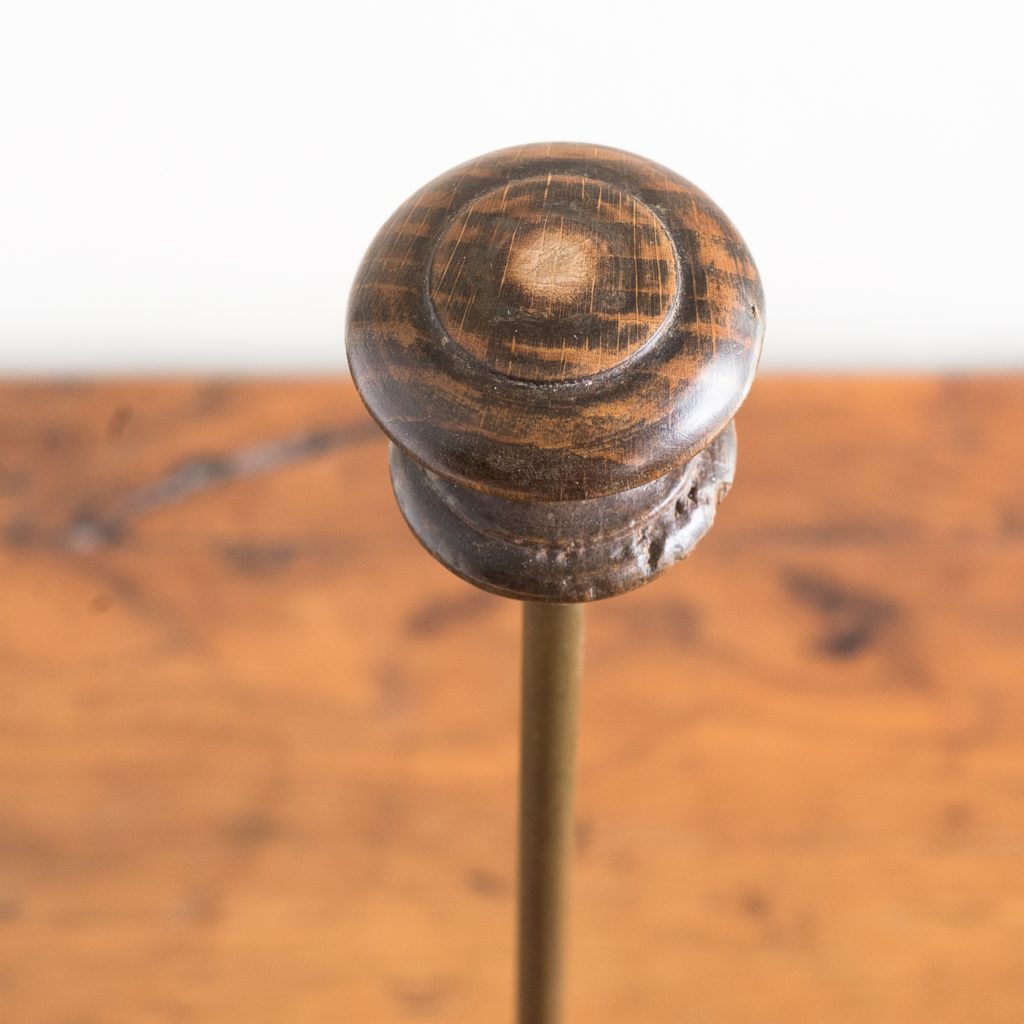 turned timber knob on brass upright