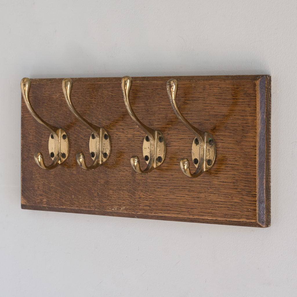 Set of four mounted brass coat hooks,-0