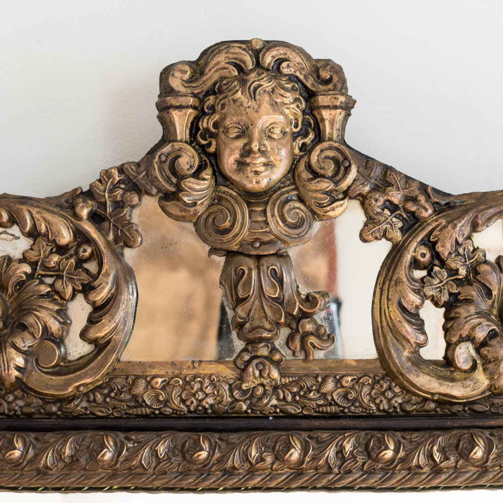 the cresting of scrolled acanthus and cherub mask in the Baroque manner,