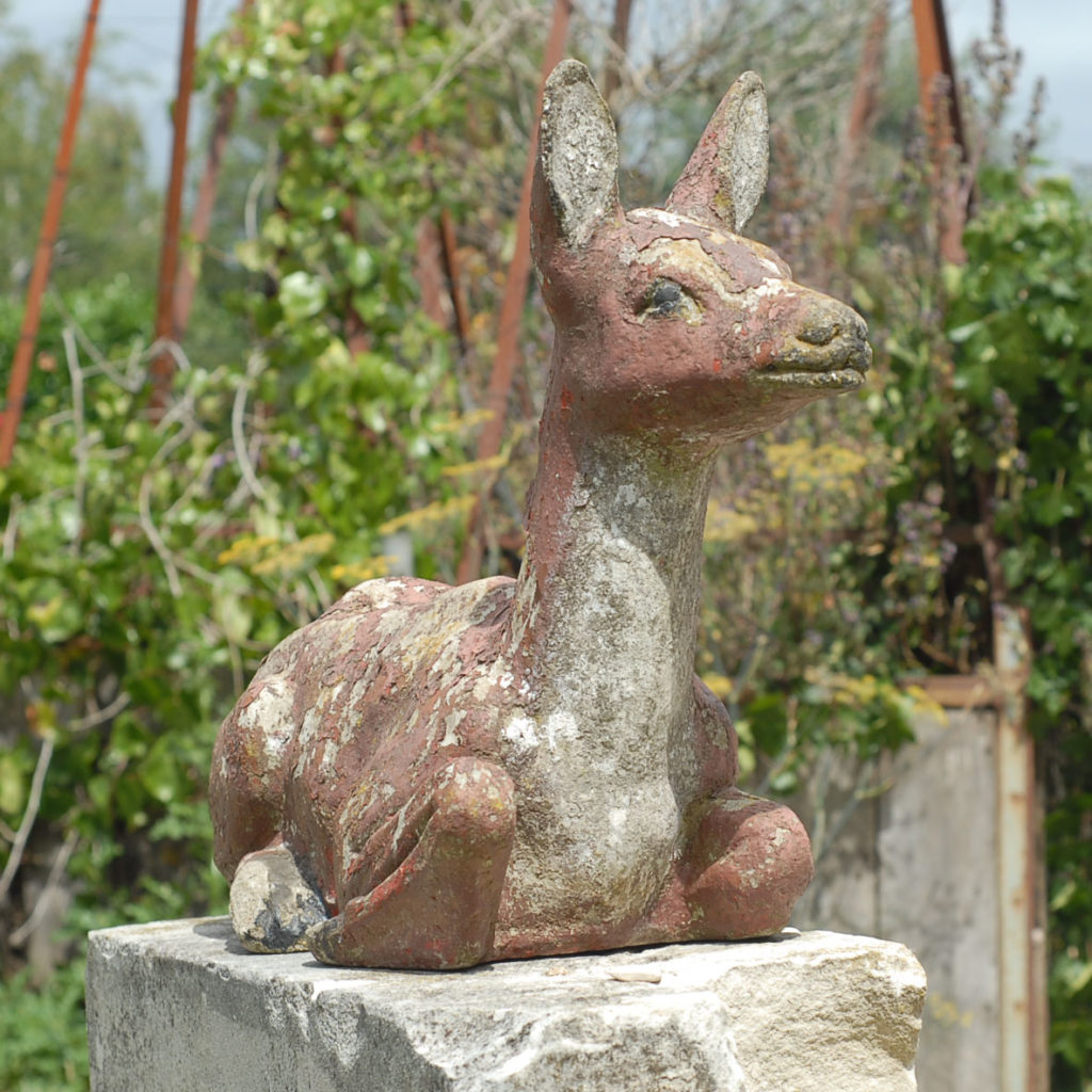 A reconstituted stone figure of a reclining fawn-0