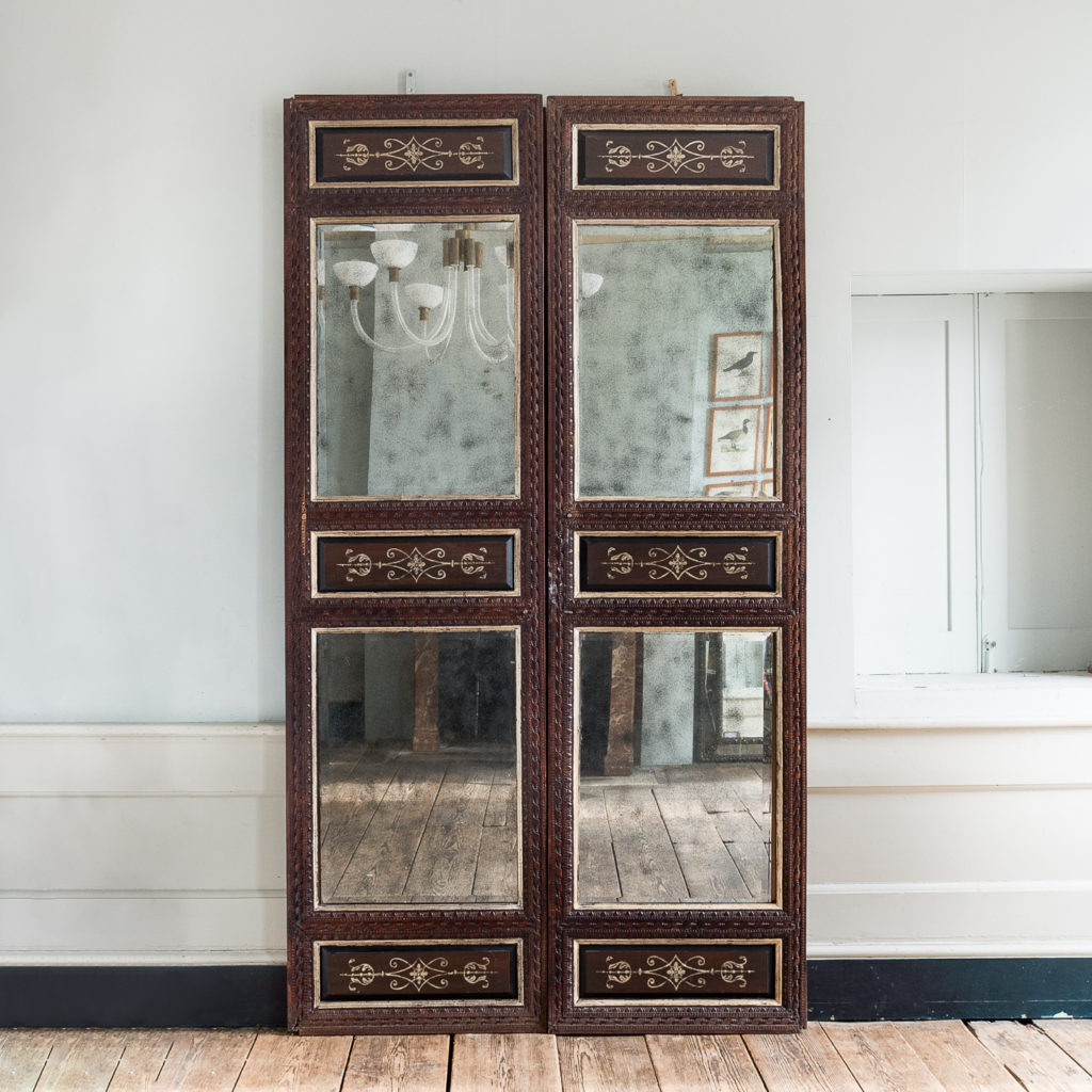 Pair of carved hardwood and mirrored door panels,