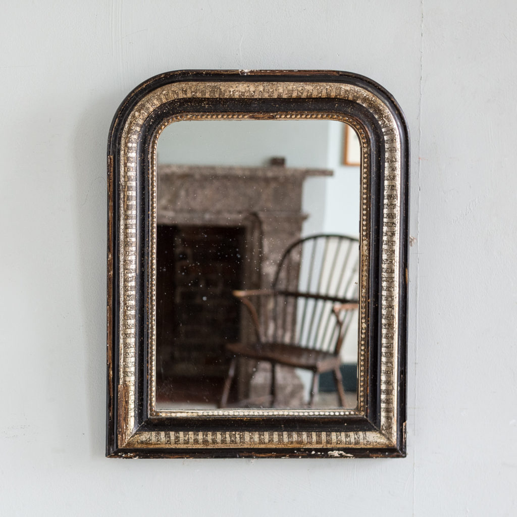 French ebonised and parcel silver-gilt wall mirror,