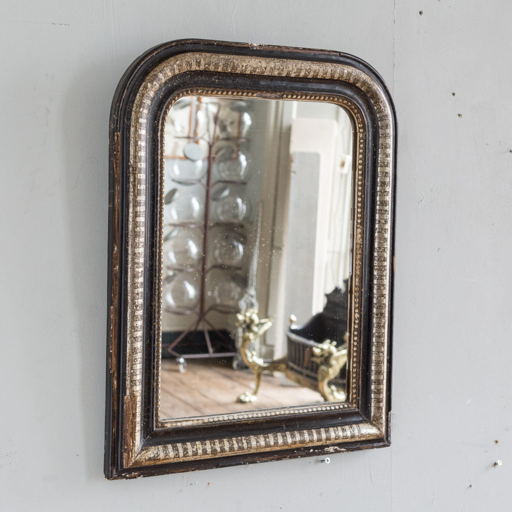 French ebonised and parcel silver-gilt wall mirror,